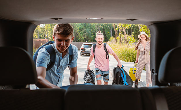 friends load car trunk with baggage