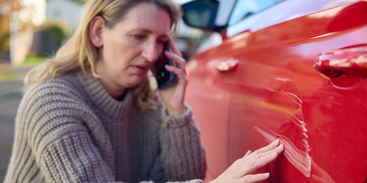 Women looking at a scratch on her car