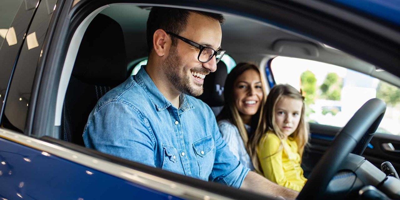 Happy family buying a new car at the car showroom.