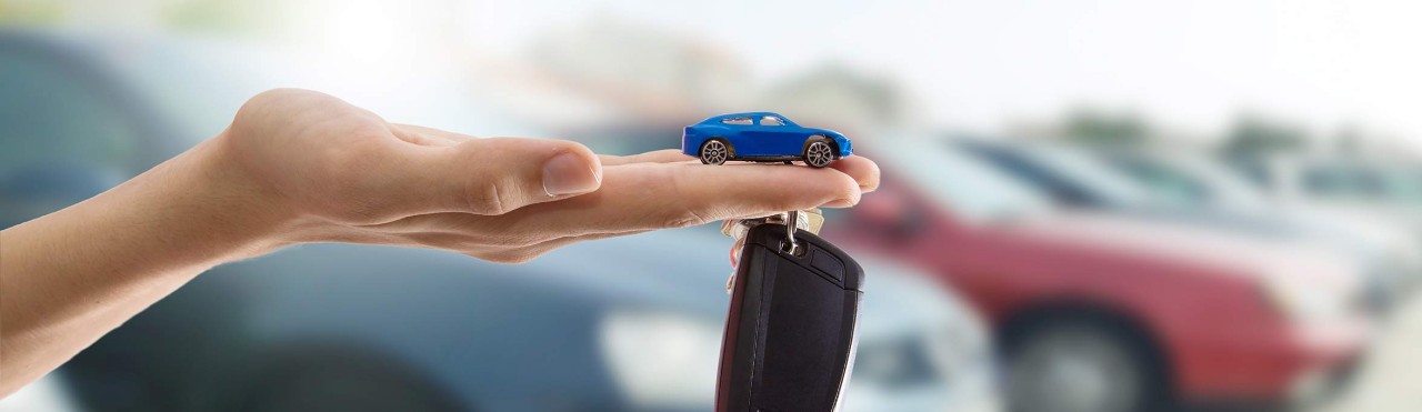Car key and a blue car on hand