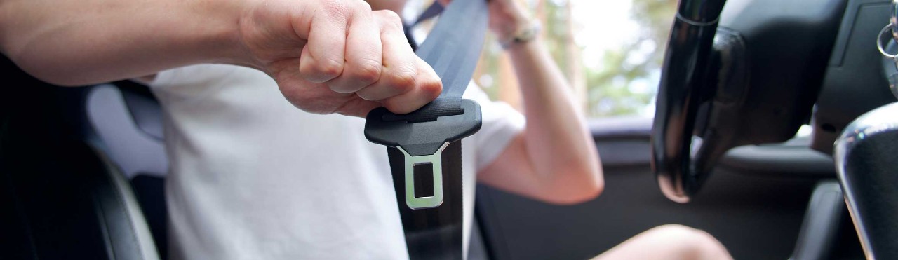  Young driver putting on his seatbelt