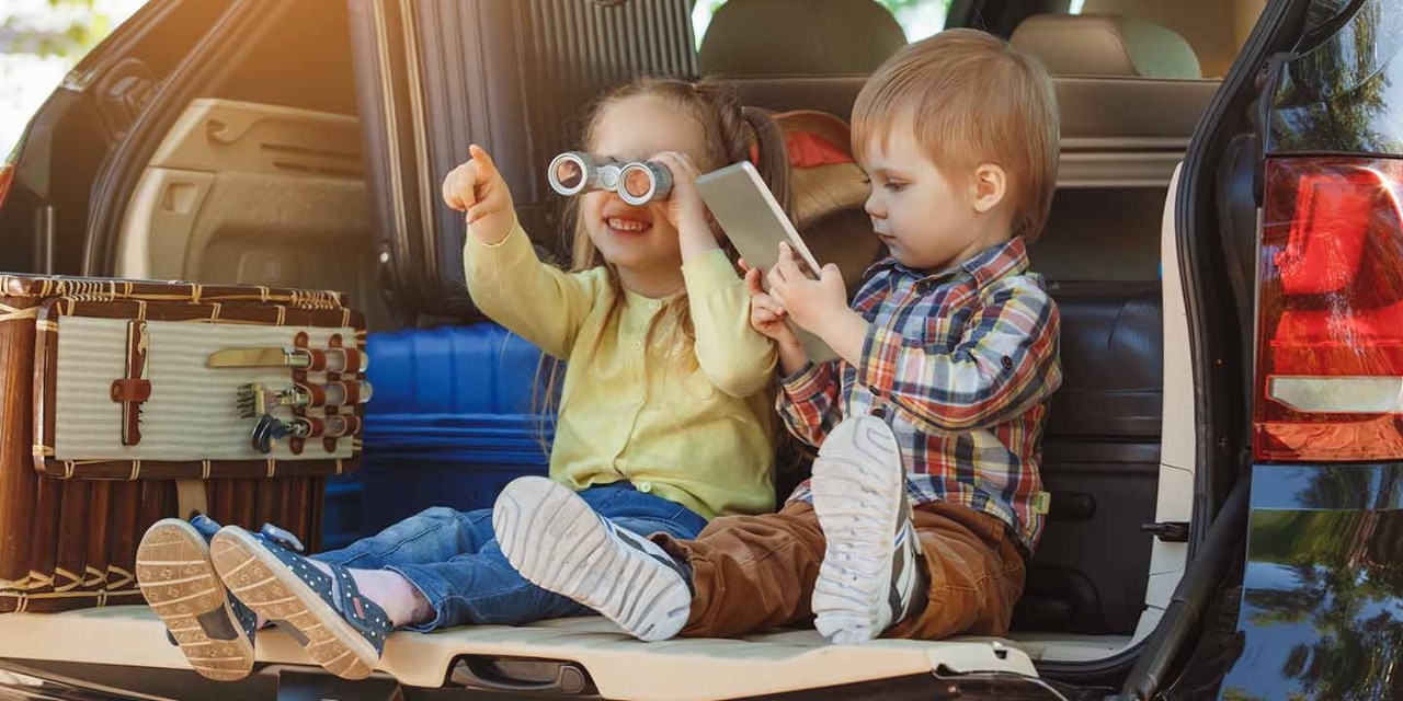 2 kids playing on the car