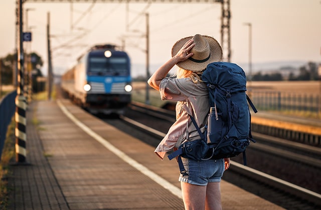 girl backpacking travel train station