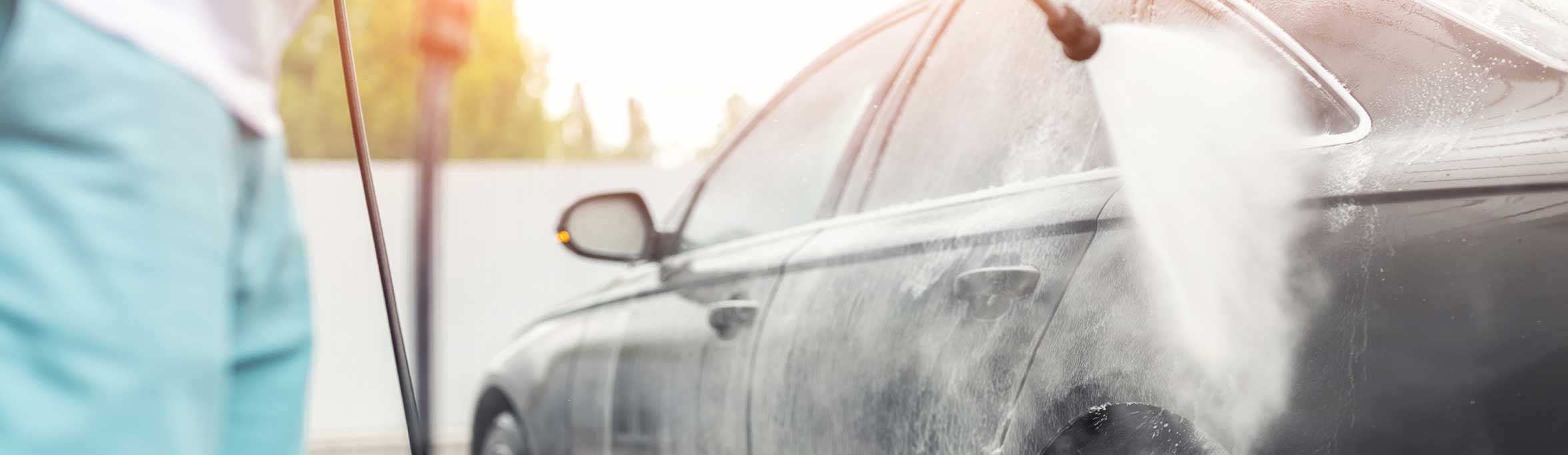 A car being washed at home with a power washer